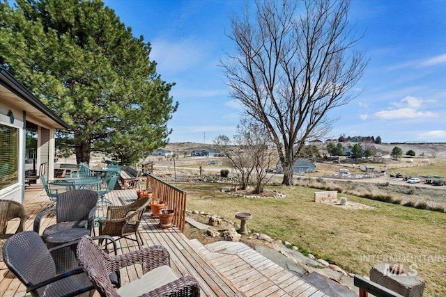 wooden deck with outdoor dining space and a yard