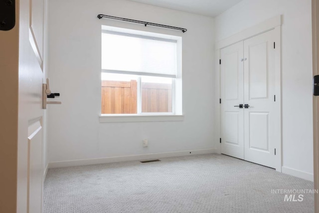 unfurnished bedroom with visible vents, baseboards, and carpet flooring