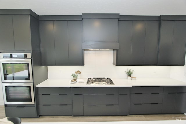 kitchen featuring tasteful backsplash, gray cabinets, and stainless steel appliances