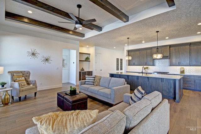 5728 S Keyport Way, Meridian, ID 83642 - living room with light wood-style flooring, ceiling fan, baseboards, recessed lighting, and beam ceiling