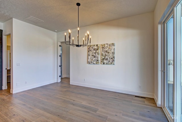 5728 S Keyport Way, Meridian, ID 83642 - unfurnished dining area with a chandelier, hardwood / wood-style flooring, and baseboards