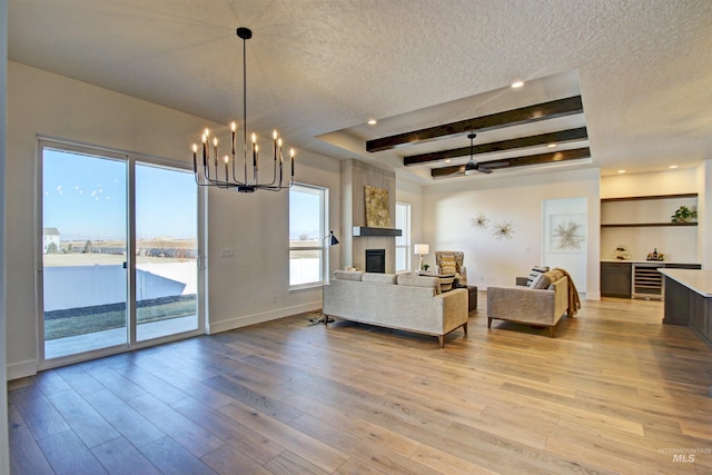 5728 S Keyport Way, Meridian, ID 83642 - living area featuring a textured ceiling, beverage cooler, a chandelier, a large fireplace, and light wood-type flooring