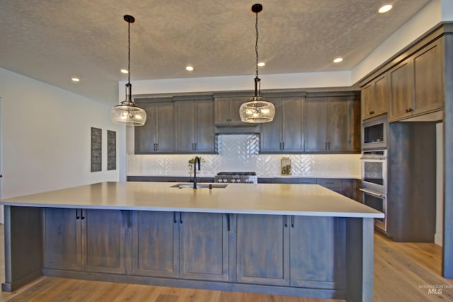5728 S Keyport Way, Meridian, ID 83642 - kitchen with a sink, built in microwave, light wood-style floors, decorative backsplash, and recessed lighting