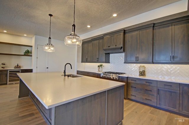 5728 S Keyport Way, Meridian, ID 83642 - kitchen featuring a sink, beverage cooler, stainless steel gas stovetop, a textured ceiling, and light wood finished floors