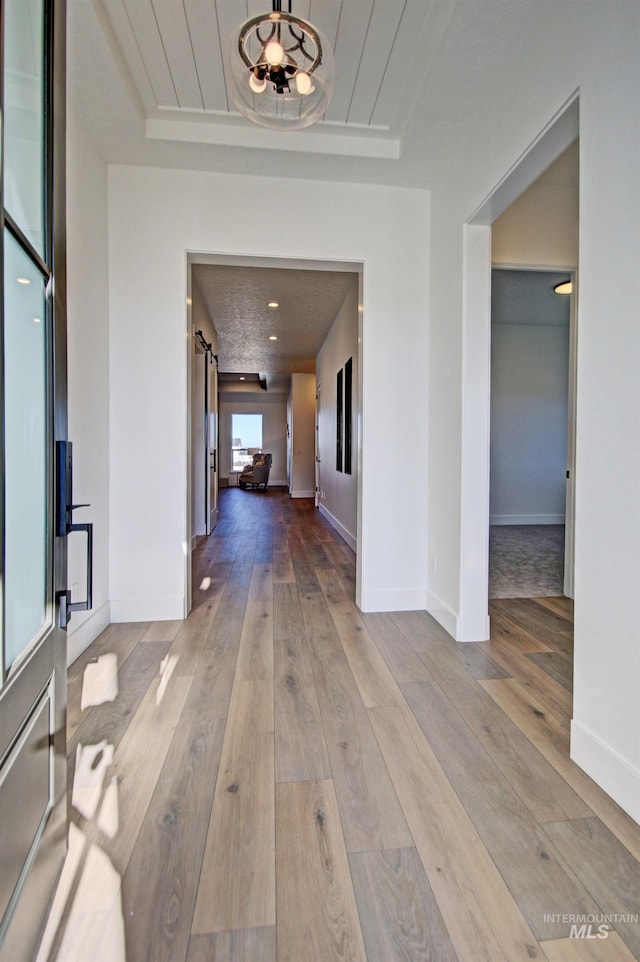 5728 S Keyport Way, Meridian, ID 83642 - corridor featuring a barn door, hardwood / wood-style floors, and baseboards