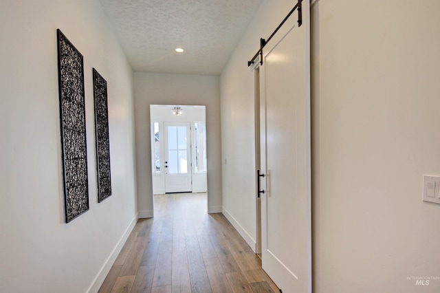 5728 S Keyport Way, Meridian, ID 83642 - corridor featuring a barn door, a textured ceiling, baseboards, wood finished floors, and recessed lighting