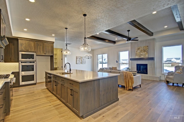 5728 S Keyport Way, Meridian, ID 83642 - kitchen featuring a sink, stainless steel appliances, light countertops, light wood-style flooring, and a textured ceiling