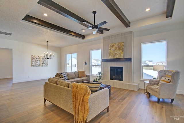 5728 S Keyport Way, Meridian, ID 83642 - living area featuring baseboards, a chandelier, wood-type flooring, a tile fireplace, and beam ceiling