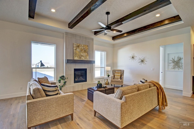 5728 S Keyport Way, Meridian, ID 83642 - living room featuring a ceiling fan, beamed ceiling, a tiled fireplace, baseboards, and wood finished floors