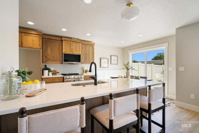 1132 S Barberry Pl, Nampa, ID 83686 - kitchen featuring appliances with stainless steel finishes, a sink, a breakfast bar, light countertops, and recessed lighting