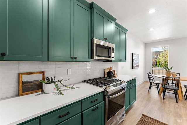 357 E Lombard Ln The Dayton, Unit The Dayton, Eagle, ID 83616 - kitchen featuring stainless steel appliances, green cabinetry, light wood-type flooring, decorative backsplash, and recessed lighting
