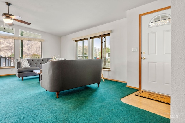 carpeted living room featuring ceiling fan and vaulted ceiling