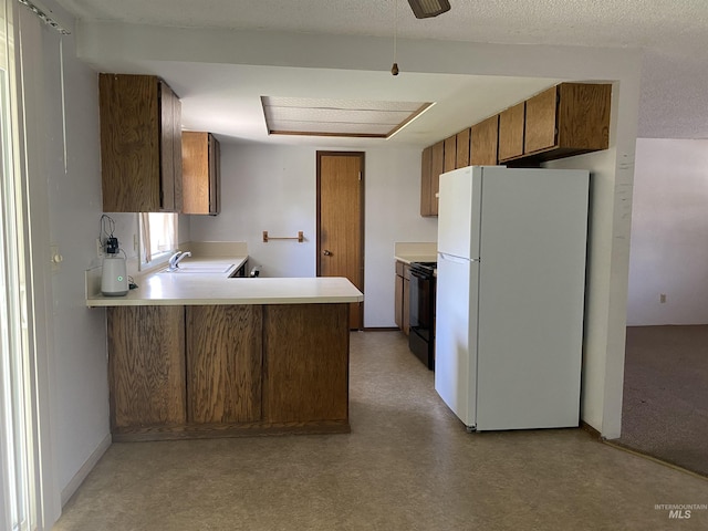 1472 En Casa Villa Dr, Mountain Home, ID 83647 - kitchen featuring freestanding refrigerator, black electric range oven, a sink, light countertops, and brown cabinetry