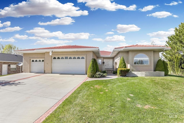 mediterranean / spanish-style house featuring a garage and a front lawn