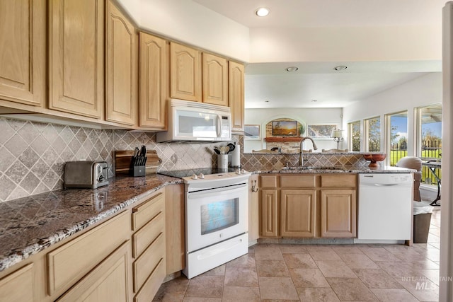 kitchen featuring sink, dark stone countertops, light brown cabinets, white appliances, and decorative backsplash