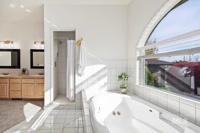 bathroom with vanity, tile walls, a healthy amount of sunlight, and separate shower and tub