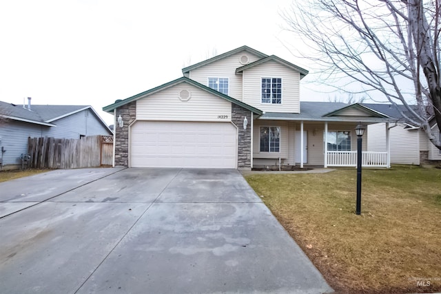 view of front of house featuring a garage, covered porch, and a front yard