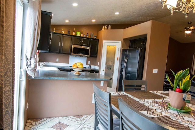 kitchen featuring sink, backsplash, stainless steel appliances, light tile patterned flooring, and kitchen peninsula