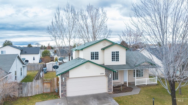 view of front of property featuring a porch, a garage, and a front lawn