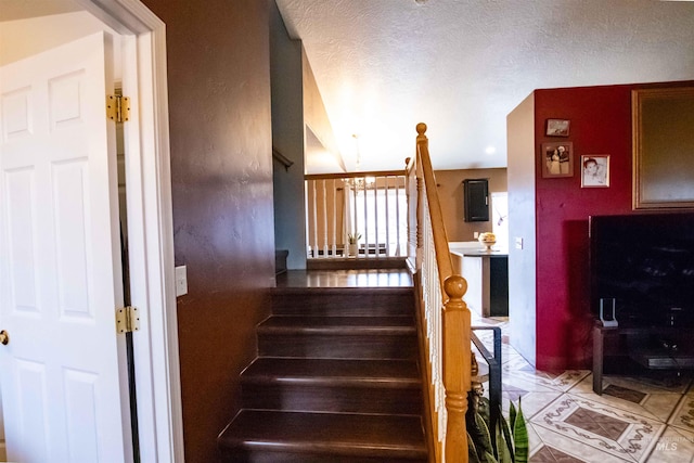 staircase with a textured ceiling