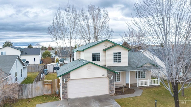 view of front of house featuring a porch, a garage, and a front lawn