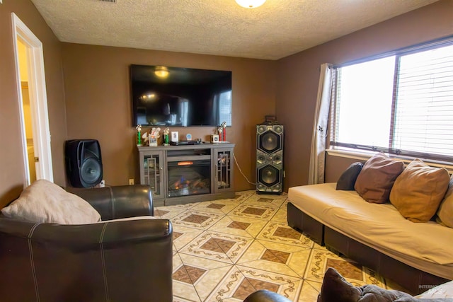 tiled living room featuring a textured ceiling