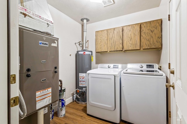 1131 Aztec Dr, Twin Falls, ID 83301 - washroom featuring water heater, cabinet space, washer and clothes dryer, and wood finished floors