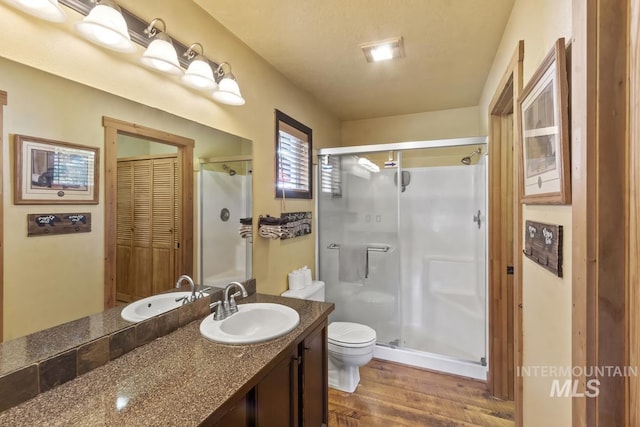 13098 Hillhouse Loop, Donnelly, ID 83615 - full bath featuring toilet, a stall shower, vanity, and wood finished floors