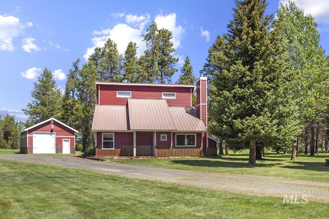 13098 Hillhouse Loop, Donnelly, ID 83615 - view of front of house with a detached garage, an outbuilding, asphalt driveway, a chimney, and a front yard