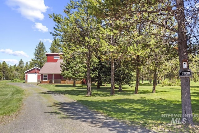 13098 Hillhouse Loop, Donnelly, ID 83615 - obstructed view of property featuring asphalt driveway, a front yard, an outdoor structure, and metal roof