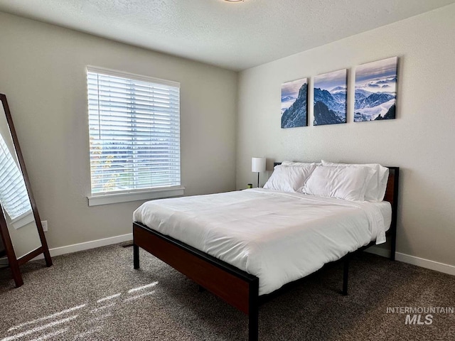 carpeted bedroom with multiple windows and a textured ceiling