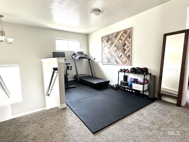 exercise area with a textured ceiling and carpet floors