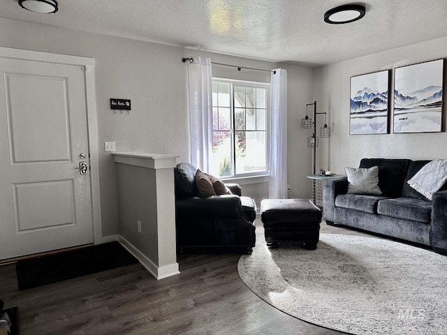 living room with a textured ceiling and dark hardwood / wood-style floors