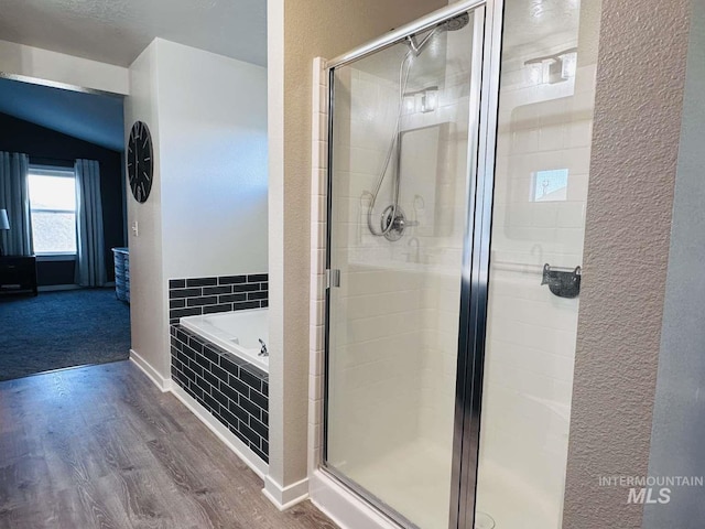 bathroom with hardwood / wood-style flooring and independent shower and bath