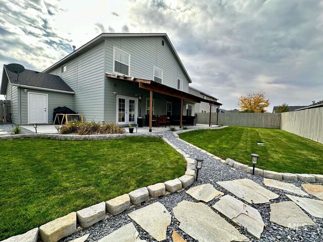 back of house with french doors, a patio, and a yard