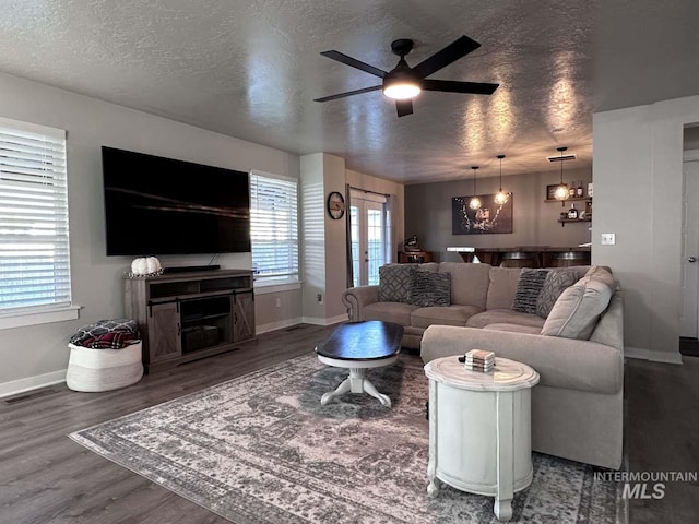 living room featuring french doors, ceiling fan, a textured ceiling, and dark hardwood / wood-style flooring