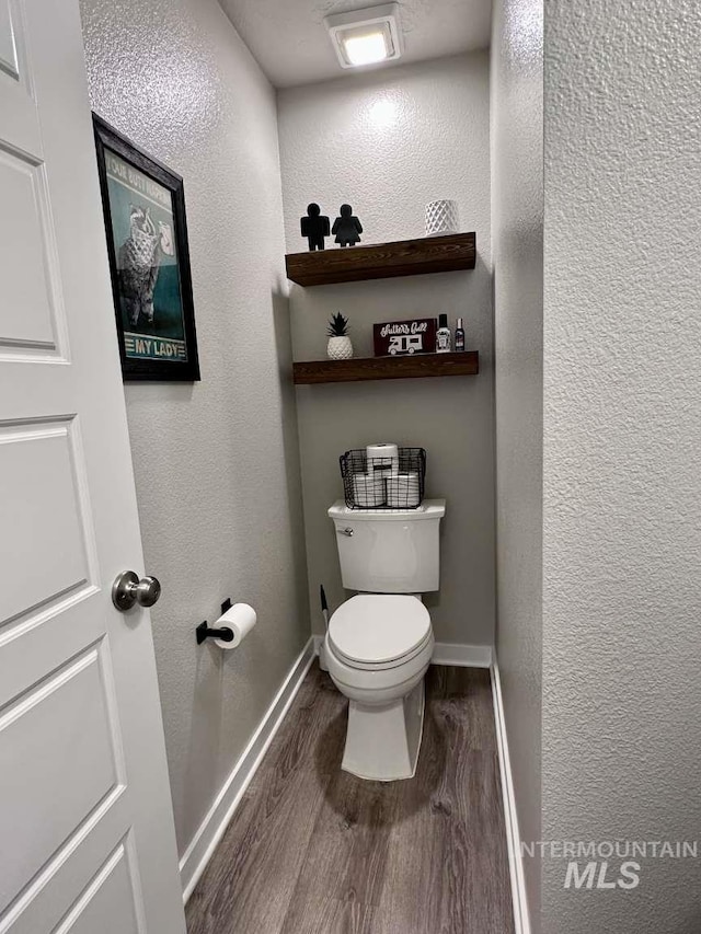 bathroom with toilet and wood-type flooring