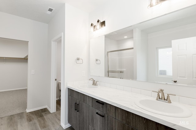 15414 Ivybridge Way, Nampa, ID 83651 - bathroom with a sink, toilet, a stall shower, and wood finished floors