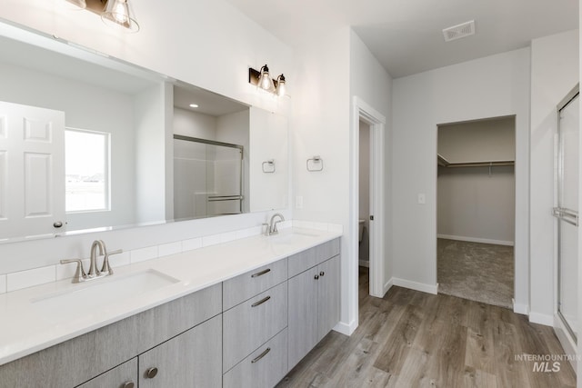 15414 Ivybridge Way, Nampa, ID 83651 - bathroom featuring double vanity, a sink, a stall shower, and wood finished floors