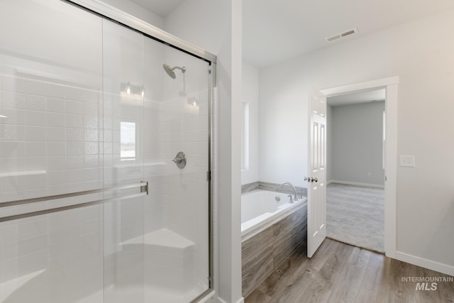 15414 Ivybridge Way, Nampa, ID 83651 - full bathroom with a bath, wood finished floors, visible vents, and a stall shower