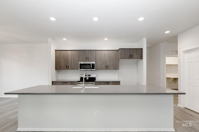 15414 Ivybridge Way, Nampa, ID 83651 - kitchen featuring a large island with sink, recessed lighting, appliances with stainless steel finishes, a sink, and light wood finished floors