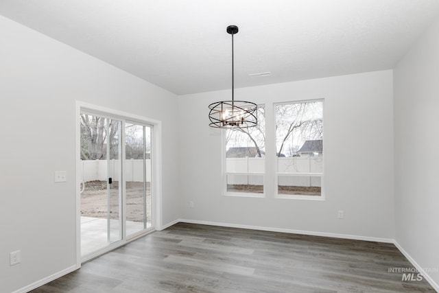 15414 Ivybridge Way, Nampa, ID 83651 - unfurnished dining area featuring baseboards, a chandelier, and wood finished floors