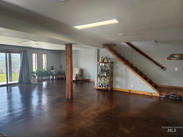 131 Beaver Nob Dr, Kamiah, ID 83536 - unfurnished living room featuring concrete floors, stairway, and baseboards