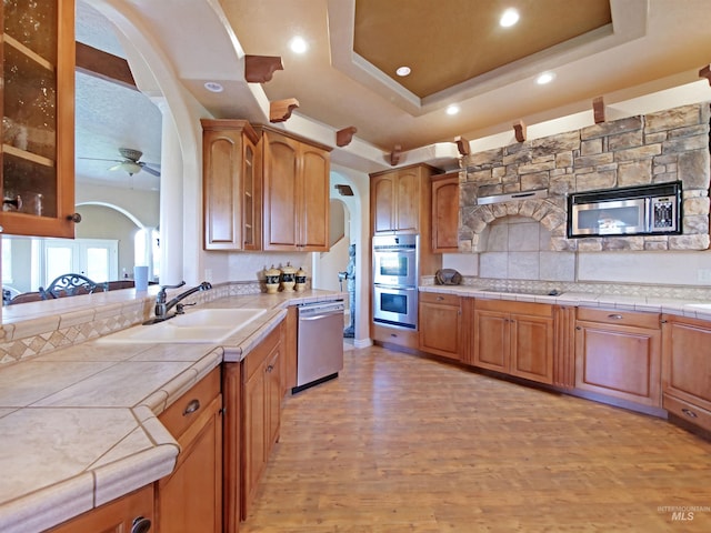 16480 Goodson Rd, Caldwell, ID 83607 - kitchen featuring light hardwood / wood-style floors, stainless steel appliances, tile countertops, and a tray ceiling
