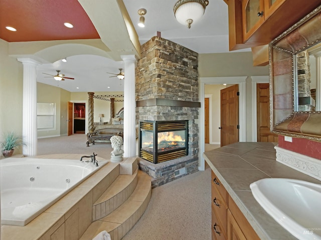 16480 Goodson Rd, Caldwell, ID 83607 - bathroom with ceiling fan, a bathing tub, decorative columns, vanity, and a fireplace
