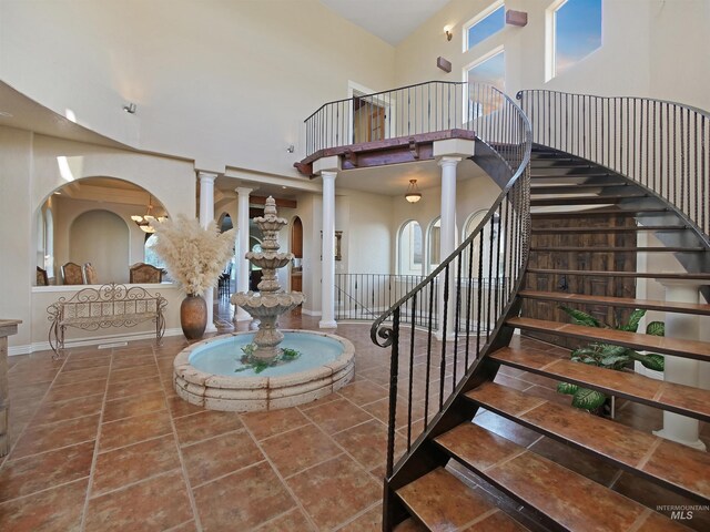 16480 Goodson Rd, Caldwell, ID 83607 - staircase with a healthy amount of sunlight, ornate columns, a towering ceiling, and tile flooring