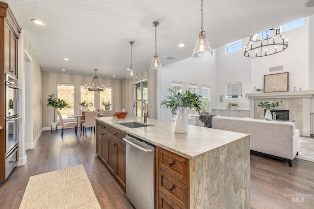 kitchen with an island with sink, decorative light fixtures, and sink