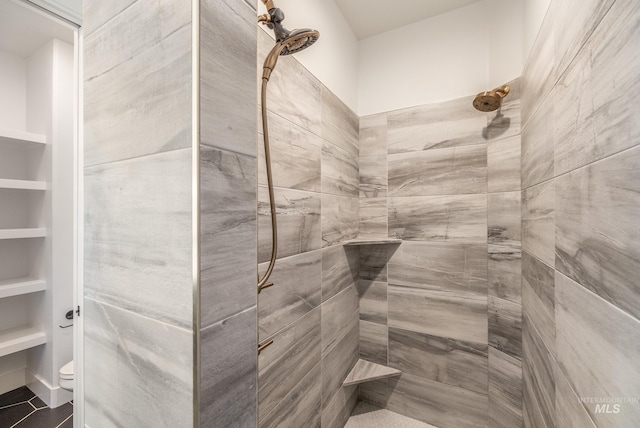 interior space with toilet and tiled shower