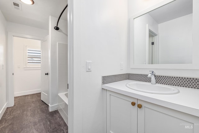 bathroom featuring hardwood / wood-style flooring, vanity, and shower / bath combination