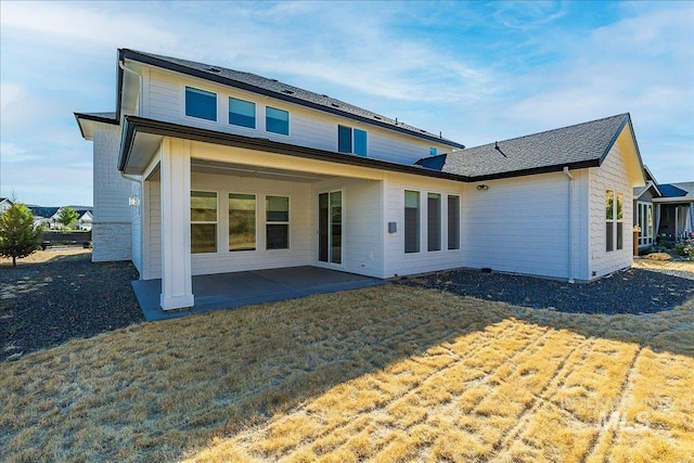 rear view of property with a yard and a patio